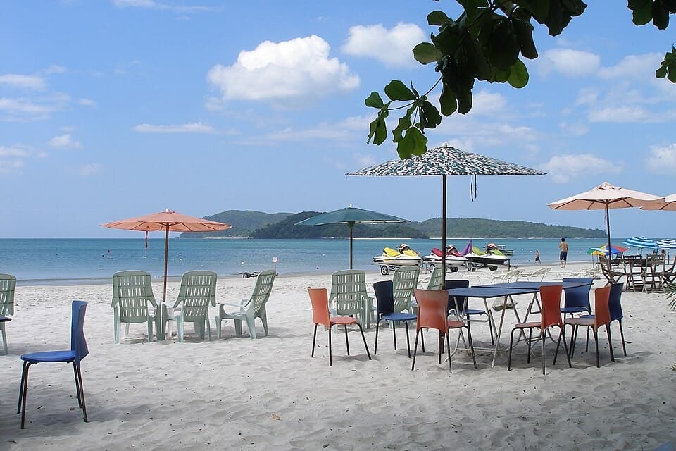 Tables and parasols on the white sand of Pantai Cenang, Langkawi, Malaysia